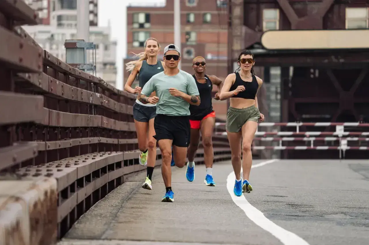 Grupa biegaczy na moście, wykonująca trening fartlek. Dynamiczne tempo i skupienie na osiągnięciu celu.